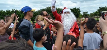 Papai Noel é recepcionado por crianças após descer de paraquedas na Emapa